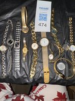 Overview of all nine wristwatches laid out on black background