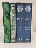 Three Folio Society books in slipcases. Two volumes of 'Parade's End' with blue cloth covers, 'The Camberwell Beauty & Other Stories' in green cover, and 'The Age of Illusion' in shrink wrap with dark cover.