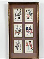 Full view of the framed shadow box containing six military uniform illustration prints arranged in two columns and three rows, showcasing vintage frame and matting.