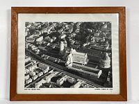 Framed aerial photograph showing the Leaning Tower of Pisa and surrounding buildings from an aerial perspective. Wooden frame visible with minor blemishes.