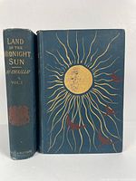 Front cover and spine of Volume I showing blue cloth with large sun and birds design, and spine text