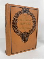 Front cover showing gold and black embossed heraldic design and title on orange-tan cloth hardcover book.