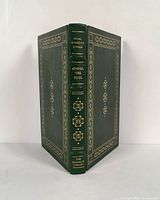 Front cover and spine of book, showing green leather cover with gold embossed designs and title