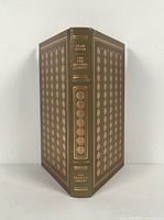 Front and back cover of leather bound book with gold tooling and title on spine