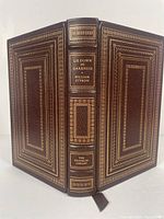 Front and back cover of the leather bound book showing embossed gold detailing and spine title.