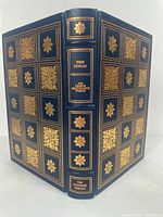 Full view of book cover and spine with gold embossed floral designs and text
