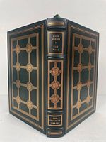 Front and back cover with spine showing detailed gold embossed design on green leather binding