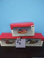 Three boxed ceramic ducks on blue background with red and cream Zellers packaging