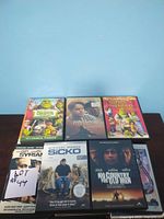 DVDs including Shrek 2, Shadowlands, Shrek The Third, Syriana, Sicko, and No Country for Old Men shown in good condition with cover art visible.