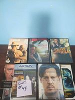 Five DVDs including Let Me In, The Descendants, and 3 Days to Kill shown on a table with a white note labeled Lot #45