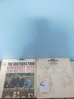 Two vinyl record album covers featuring The Brothers Four greatest hits and a Ray Conniff album with visible track list.