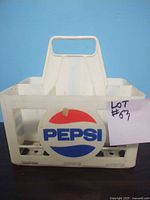 Front view of the off-white plastic crate with Pepsi round logo and built-in handle