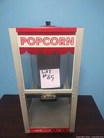 Front view of Doluce popcorn maker showing 'POPCORN' label and metal kettle inside