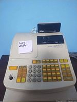 Beige Royal Alpha 880 cash register with all keys, metal key inserted in lock, shown from top angle.
