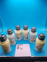 Full lot of six vintage Japanese salt and pepper shakers, three pairs, with floral hand-painted designs on opaque glass and metal tops