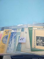 Lot of 10 vintage sheet music pieces in plastic bags, showing colorful front covers.