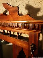 Close-up of the top carved crest and vertical groove detailing on the oak wood frame.
