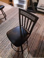 Single stool on carpet showing seat, frame and backrest design.