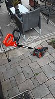 Full view of Black & Decker electric lawn edger showing handle, wheels, and motor housing.