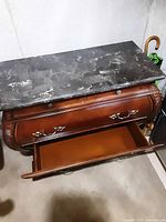 Front view of dresser with one bottom drawer open revealing interior