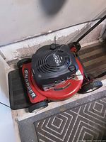 Front view showing the red mower deck, Snapper branding, black engine cover with 5.5 HP marking, and front wheels