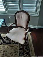 Front view of one antique Victorian chair showing wooden frame and beige fabric upholstery