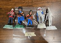 Overview of five 90mm metal cast British figures in original green metal bases, three painted in colorful historic military attire, two unpainted.