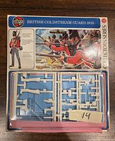 Front view of unopened Airfix plastic model kit for British Coldstream Guard 1815 showing plastic sprues with soldier parts in 54mm scale, and illustrated box art showing guardsmen in red coats and black hats aiming muskets.