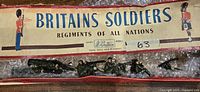 Full view of 5 WW1 machine gunner lead soldier figures in original vintage Britain's Soldiers box with the box label visible.