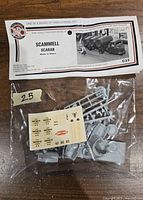Photo of unopened plastic model kit parts on sprues with decal sheet visible in plastic bag under header card.