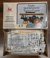 Open box showing white plastic parts on sprue frames inside original packaging with box lid showing model illustration and product information.