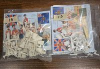 Two plastic bags containing assorted unassembled white plastic miniature parts on sprues, along with printed instruction or decal sheets depicting the 42nd Royal Highland Regiment Blackwatch miniatures.