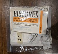 Plastic miniature kit parts in a resealable plastic bag with a branded header card labelled Historex Figurines Historiques A Monter Et A Peindre Kettledrummer Carabiniers 1810-1815. Contents include unassembled parts of the figure visible through the plastic bag.