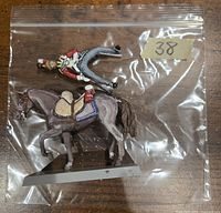 Front view of painted Lifeguard soldier miniature and horse on a display base inside a plastic bag.