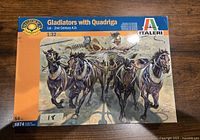 Box cover of Italeri Gladiators with Quadriga 1/32 scale plastic model kit showing artwork of a quadriga chariot drawn by four horses with gladiators aboard, from 1st - 2nd Century A.D.