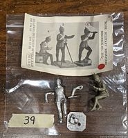Two unpainted Rose military metal miniatures in original bag with packaging card, showing miniatures A and C from the set.