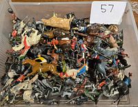 Top view of plastic container holding numerous painted metal miniature soldiers and horses, showing the varied colors and worn paint.