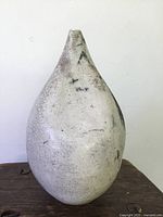 Front view of the artisan pottery vase showing the rounded shape, crackle glaze, and surface wear.