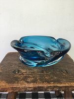 Side view of mid-century blue Chalet glass bowl with sculptural folds and thick glass.