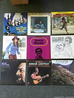 Photo of nine vinyl record covers arranged on floor, featuring artists such as Gordon Lightfoot, Stevie Wonder, Ella Fitzgerald, and soundtracks.