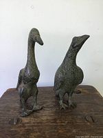 Front view of two metal bird statues showing size and sculptural detail.