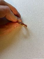 Side view showing channel-set pink gemstones along band