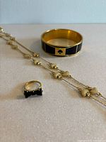 Single photo showing the ring, necklace, and bracelet closely to highlight details