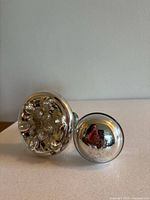 Both mercury glass door knobs side by side showing one plain and one floral design