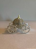 Front view of silver enamel pumpkin carriage trinket box with rhinestone accents and white handle detail.