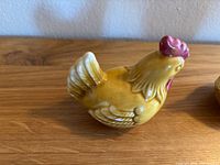 Side view of one yellow ceramic rooster salt or pepper shaker with red comb and wattle.