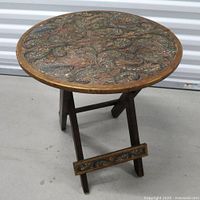 Full view of folding side table showing leather top and wooden base