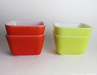 Four Pyrex dishes stacked in pairs, showing exterior colors