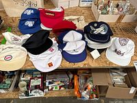View of all hats and visors laid out on wooden table showing branding and condition