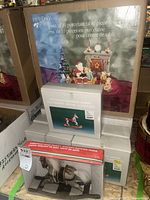 Photo showing boxed Holiday Time 10-piece Christmas porcelain table centerpiece set with festive figurines including Santa and fireplace motif.